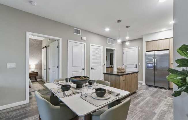 Dining area with a table and chairs and a kitchen in the background at Array La Mesa, California