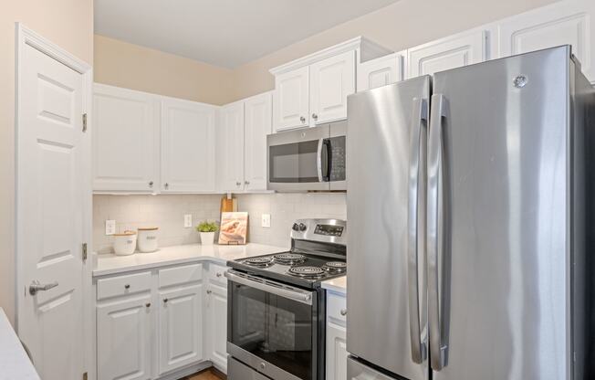 a kitchen with white cabinets and stainless steel appliances