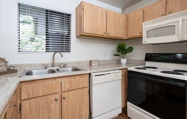A kitchen with wooden cabinets and a white dishwasher.