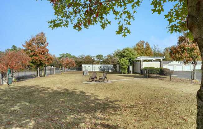 A dog park with a picnic table and a fence.