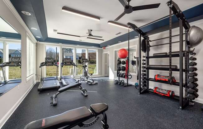 addison point interior resident gym with weights and equipment and windows