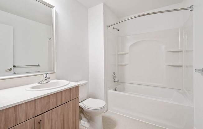 A white bathroom with a sink, toilet, and bathtub.