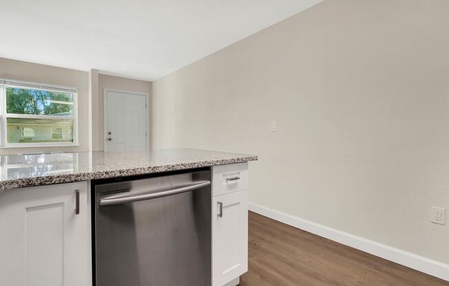 Addison Lane apartments in Gainesville, FL photo of Granite Countertopsa kitchen with an island and a dishwasher