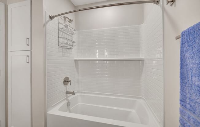a bathroom with a white tub and a white shower curtain