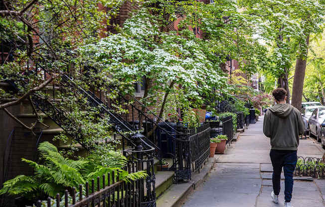 a man is walking down a sidewalk at The Paxton, Brooklyn, NY