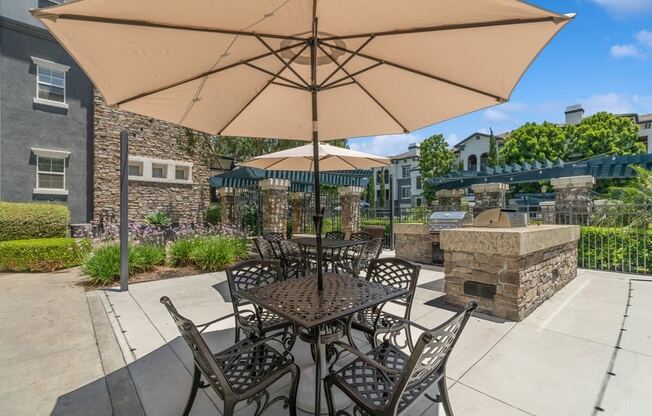 a patio with a table and chairs and a fire pit