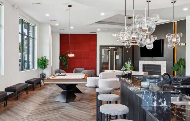 A modern kitchen with a black countertop and a large island with a table and chairs.