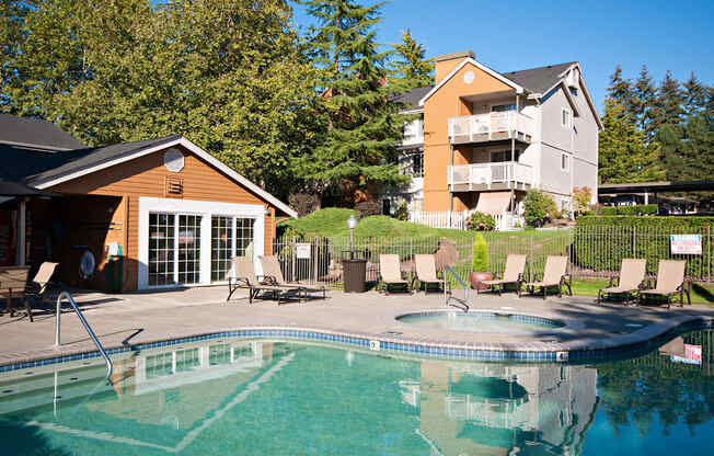 A swimming pool with a slide and chairs around it.