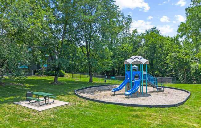 a playground with a blue swing set in a park