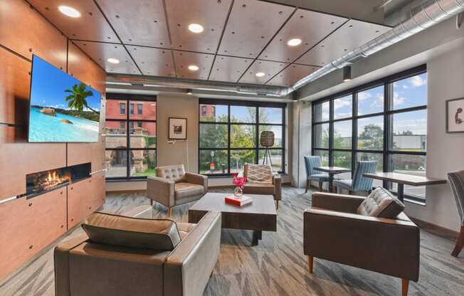 a lounge area with couches chairs and a coffee table with a vase of flowers on