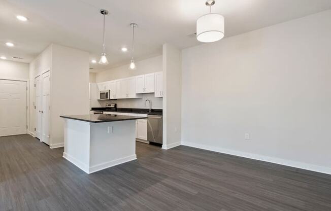 an empty living room and kitchen with a counter top