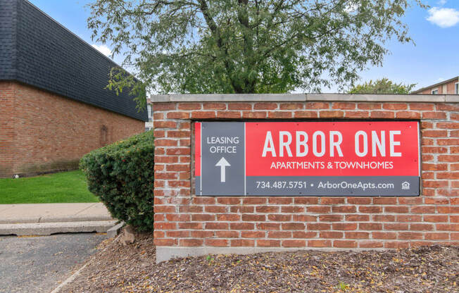 a brick building with a sign that reads arbor one apartments  townhomes
