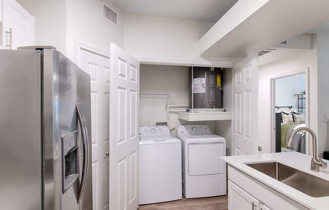 a kitchen with a washer and dryer and a sink