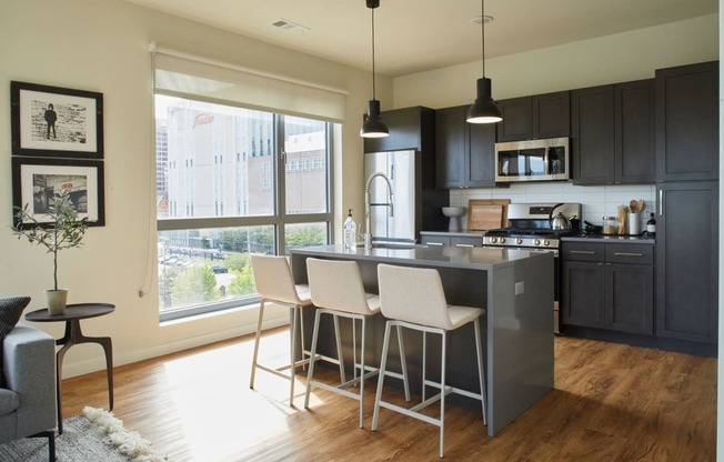 a kitchen with an island and white bar stools