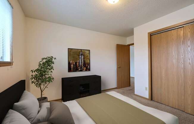 Bed and a dresser in a room at Parkwest Gardens West Fargo, ND 58078 