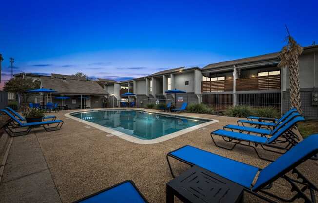 a swimming pool with chairs and tables around it