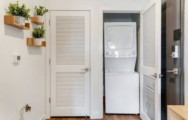 A small laundry room with a white refrigerator and a washer and dryer