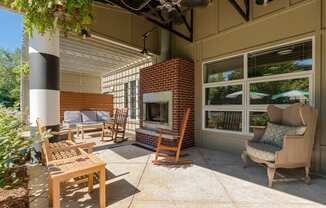 a covered patio with a fireplace and chairs at Village Club of Royal Oak, Royal Oak, MI