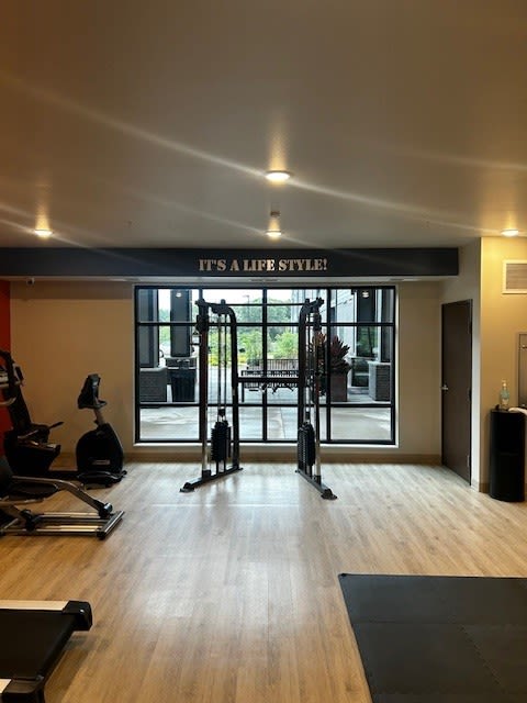 a gym with exercise equipment and a large window