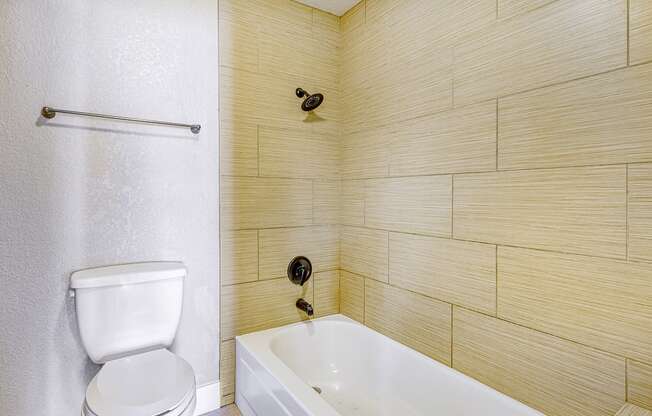 a bathroom with a toilet and a tub and a sink