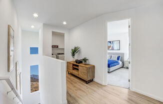 a living room with a bed and a wooden floor