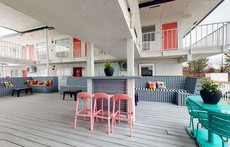 A white building with a balcony and a table with chairs.