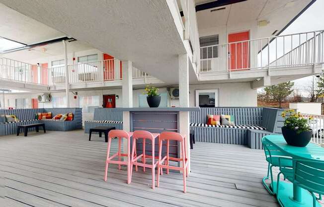 A white building with a balcony and a table with chairs.