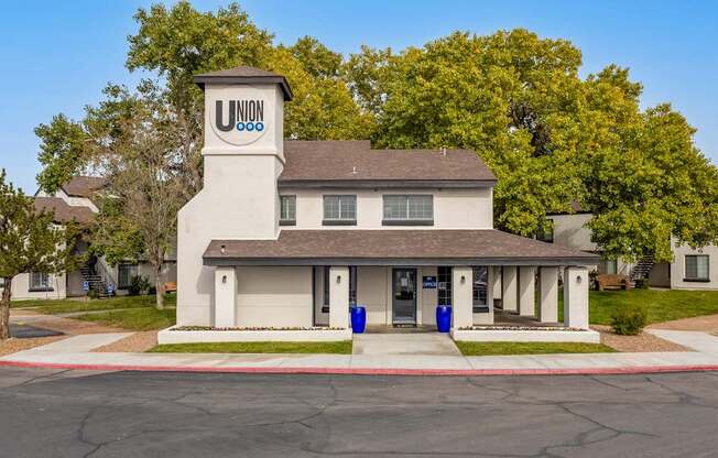 a white building with a clock tower on the corner of a street
