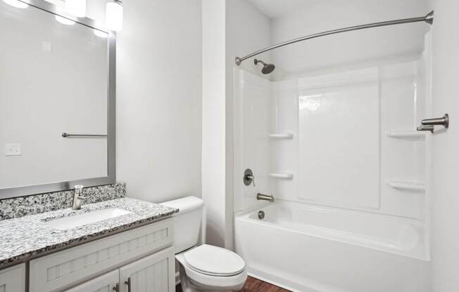 A white bathroom with a toilet, sink, and bathtub.