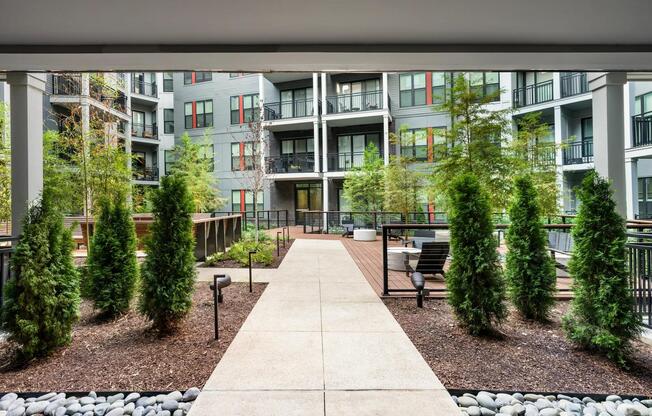 Lushly landscaped courtyard featuring cozy fire pits, ample seating, and modern finishes—perfect for relaxing or socializing just steps from home.