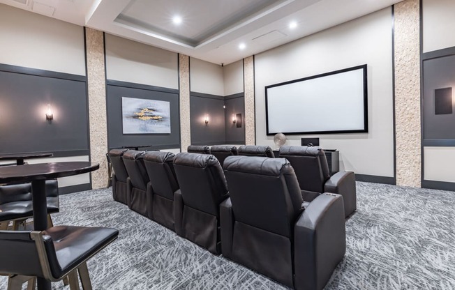 a large screening room with leather chairs and a projector screen