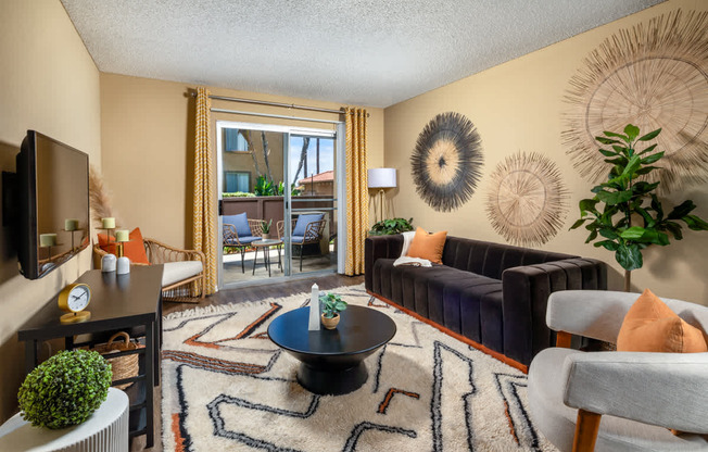 A living room with a black coffee table and a rug with a pattern.