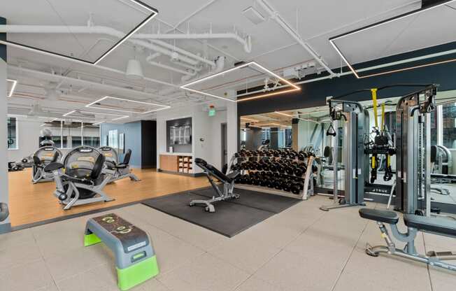 a gym with weights and cardio machines and yoga mats