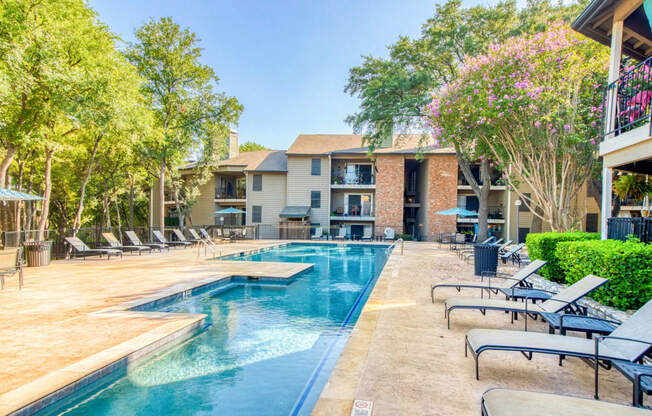 Pool area with lounge chairs at Hillside Creek Apartments in Austin, TX