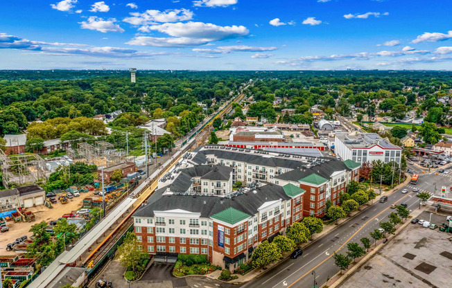 an aerial view of a large city with green trees and a blue sky at West 130, West Hempstead, NY 11552