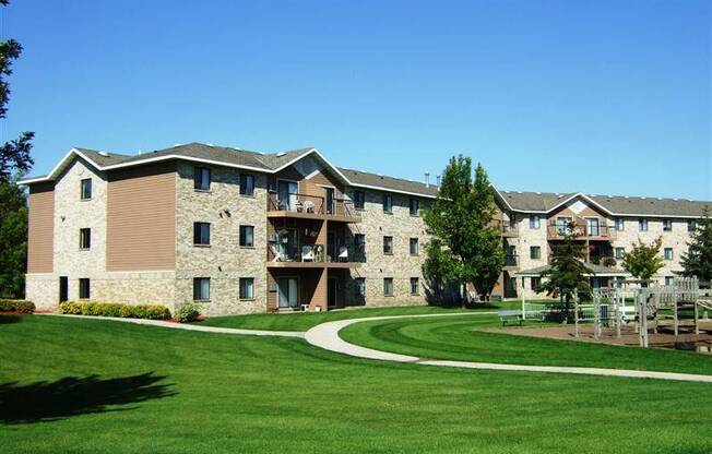 a large apartment building with a green yard