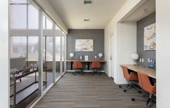 a conference room with a desk and chairs and a window