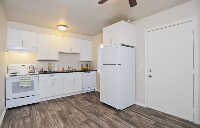 an empty kitchen with white cabinets and a white refrigerator  at Woodhaven, Everett, 98203