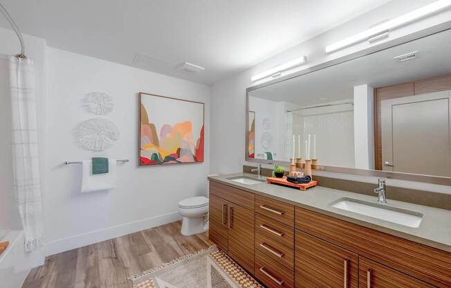 A bathroom with a wooden vanity and a white toilet.