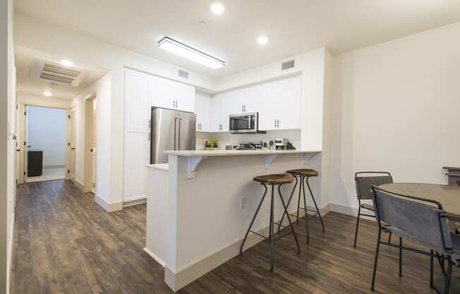 a kitchen with a counter and a bar with three stools