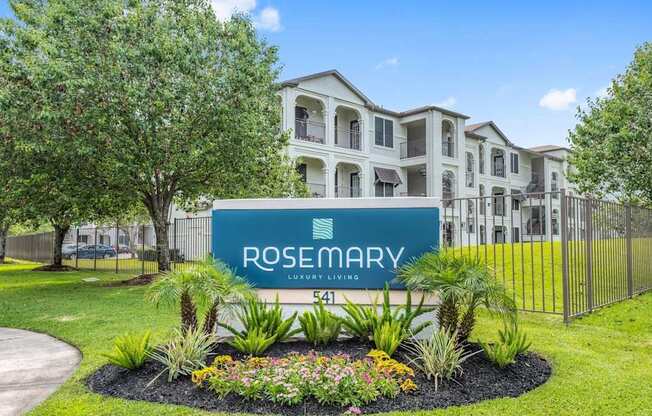 A sign for Rosemary Luxury Living in front of a building.