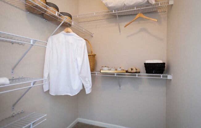 a walk in closet with a white shirt on a hanger