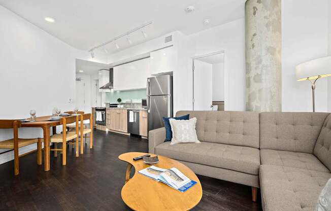 A modern living room with a grey couch and a wooden coffee table.