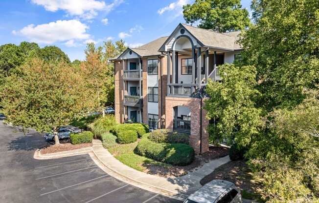 the view of an apartment building with a parking lot and trees at View at Lake Lynn, North Carolina, 27613