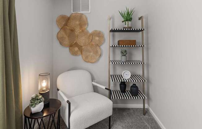 A living room with a chair, a table, a shelf, and a wall art.