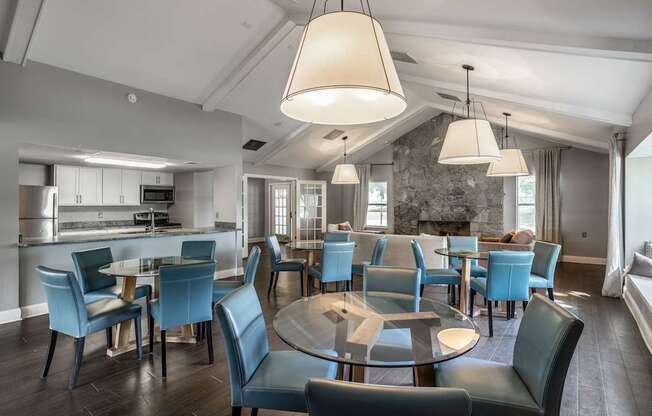 A modern dining room with a glass table surrounded by blue chairs