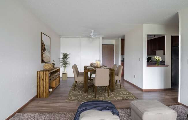 a dining room and living room with white walls and wood floors at Pheasant Park Apartments, New Hope