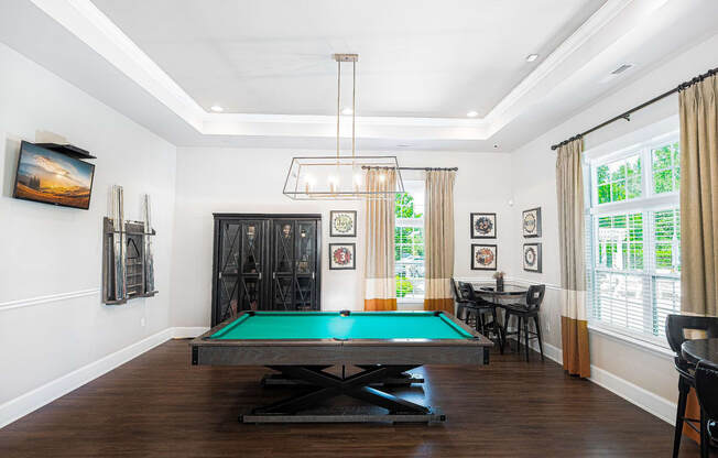 a living room with a pool table and a chandelier