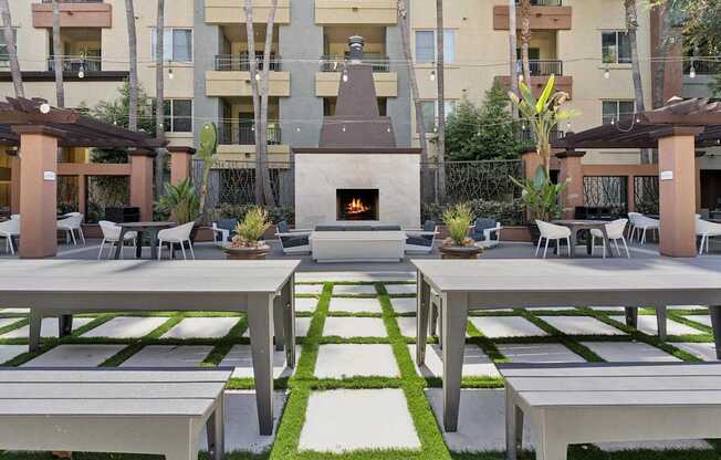 A patio with a fireplace and seating area. at The Kitt at Warner Center Apartments, Woodland Hills
