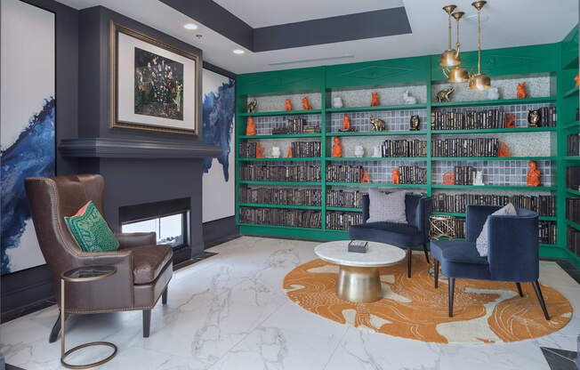 a library with chairs and a table and a fireplace